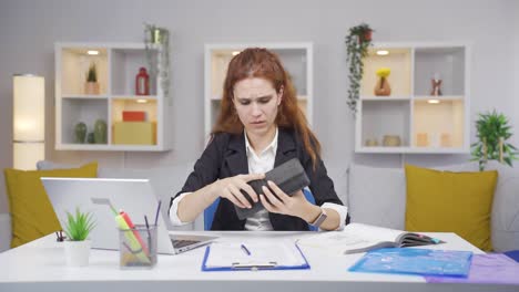 Home-office-worker-woman-showing-her-empty-wallet-to-the-camera.
